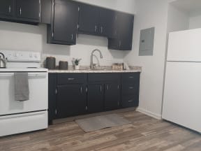 a kitchen with dark cabinets and white appliances