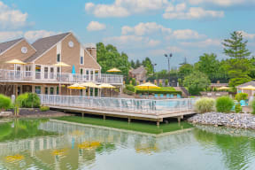 a house on the water with a large deck with umbrellas