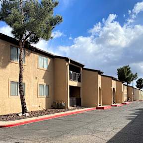 Apartment complex with a tree in front of the first building.