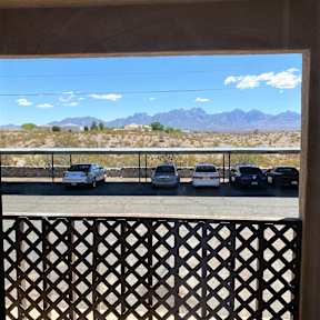 A parking lot with cars and a mountain range in the background.