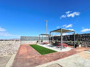 A picnic area with a table and chairs under a shelter.