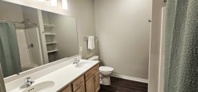 a bathroom with a toilet sink and mirror and a shower