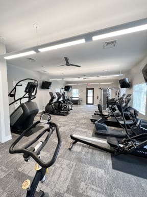 a gym with treadmills and other exercise equipment in a building