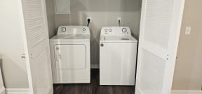 a white washer and dryer in a room with a door