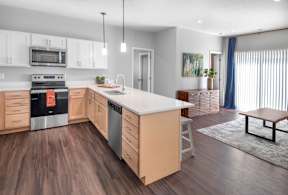 A modern kitchen with wooden floors and a large island.