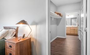 A lamp on a wooden dresser in a room.