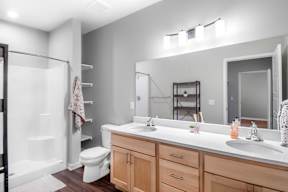 A bathroom with a toilet, sink, and mirror.
