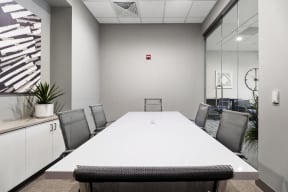 a meeting room with a white table and chairs