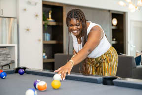 a woman playing pool in her living room