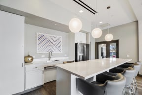 a kitchen with white cabinetry and a large white island with a white countertop and black