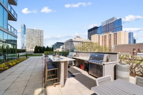 a rooftop patio with a grill and dining table