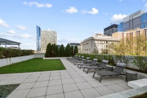 an outdoor terrace with a grassy area and a view of the city