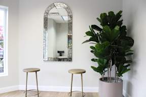Two stools are placed in front of a mirror.