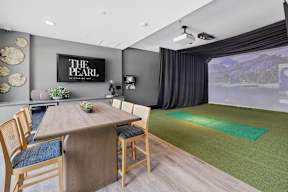 A conference room with a table and chairs and a screen on the wall.