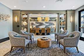 A living room with grey chairs and a wooden coffee table.