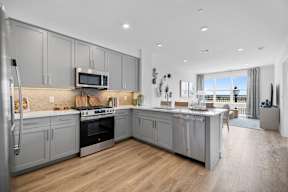 A modern kitchen with wooden floors and stainless steel appliances.