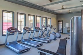 a fitness room with cardio equipment and windows at Century Lakeshore Crossings, Alabama, 35211