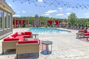 a swimming pool with red chairs and tables around it at Century Lakeshore Crossings, Birmingham, 35211