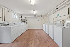 an empty laundry room with white washers and dryers
