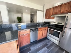 Kitchen with granite countertops and stainless steel appliances at Barracks West in Charlottesville, VA