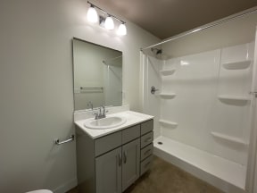 Spacious bathroom with grey cabinets and large mirror