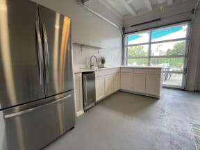 a kitchen with a large window and a stainless steel refrigerator