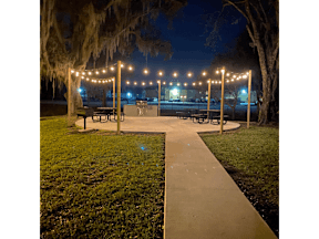 a park with benches and lights at night at Waters Edge Apartments, Florida, 33803