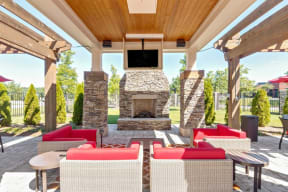 a covered patio with furniture and a stone fireplace at Century Lakeshore Crossings, Birmingham, AL