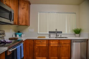 a kitchen with wooden cabinets and stainless steel appliances