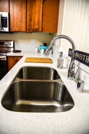 a kitchen sink with a sign that says how sweet he is