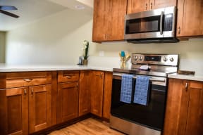 a kitchen with wood cabinets and stainless steel appliances