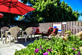 a patio with a table and chairs and a red umbrella