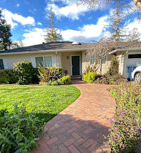 a home with a brick pathway leading to the front door
