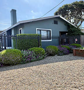 A house with a grey roof and a black fence.