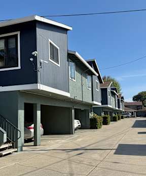 A row of houses with garages and driveways.