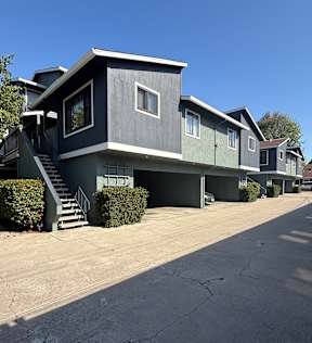 A grey house with a white window and a grey garage door.