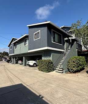 A house with a garage and a car parked in front.