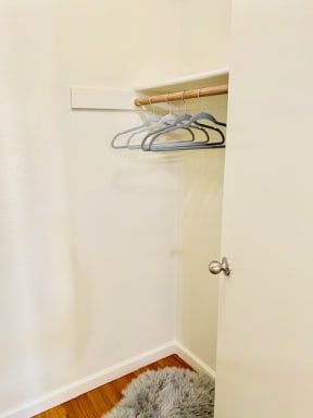 an empty closet with some hangers on a rack