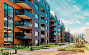 A modern apartment complex with balconies and a wooden walkway.