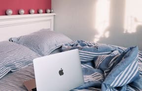 messy bed with computer