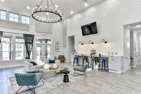 A modern living room with a white sofa set, a wooden coffee table, and a large chandelier.