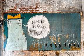 a mural on the side of a building that reads invest in good thinkers