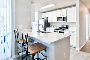 a kitchen with a large island with three stools