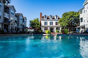 apartments with a large swimming pool in front of a house