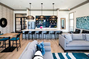 a living room with a kitchen and a couch and chairs