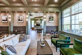 A living room with a white couch and green chairs.