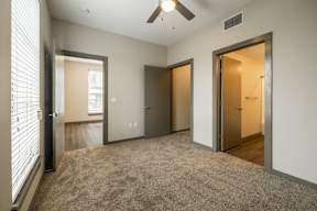 Carpeted bedroom with ceiling fan, closet, and bathroom at The Tennessee Brewery, Memphis, TN