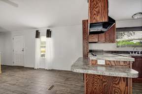 a kitchen and living room with white walls and wood floors at Regency Village, Texas