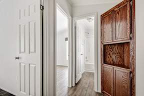 a hallway with a wooden cabinet and a white door at Regency Village, San Antonio