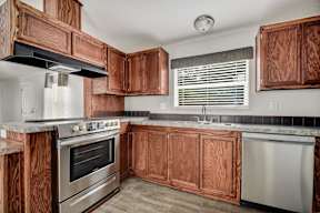 Kitchen with wooden cabinets and stainless steel appliances at Regency Village, San Antonio, TX, 78239